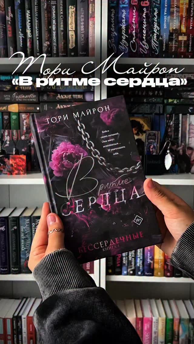 Книга В ритме сердца на фоне домашней библиотеки