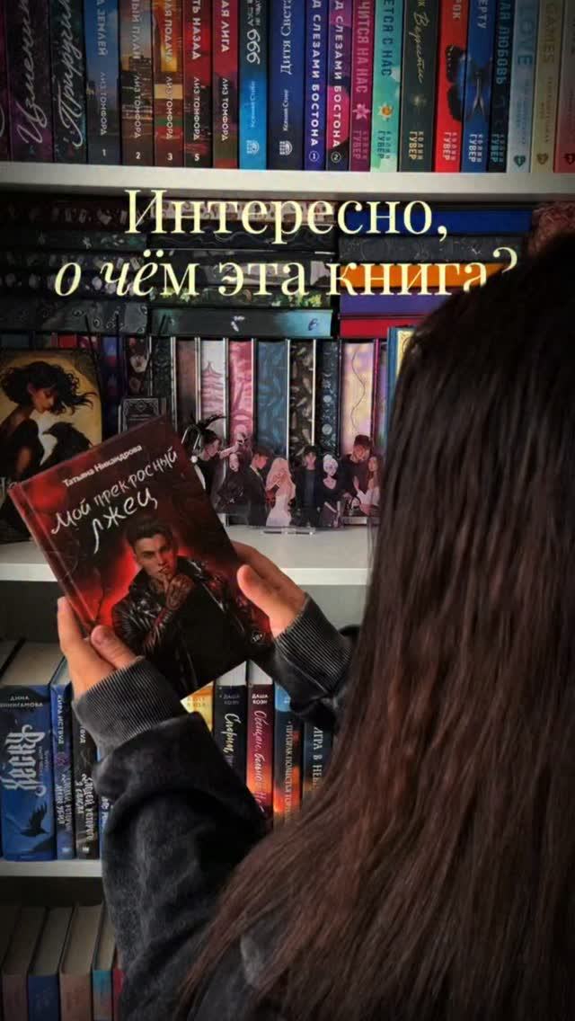 Оля читает книгу у своей домашней библиотеки